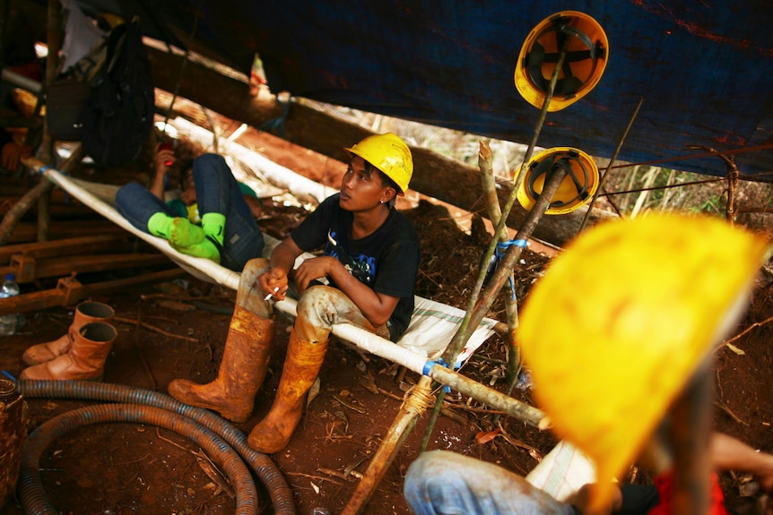 A worker smokes during a break at an Indonesian nickel mine