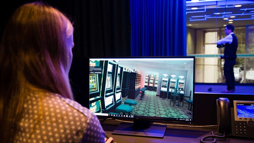 A technician at a computer console using virtual reality to replicate a poker machine venue.