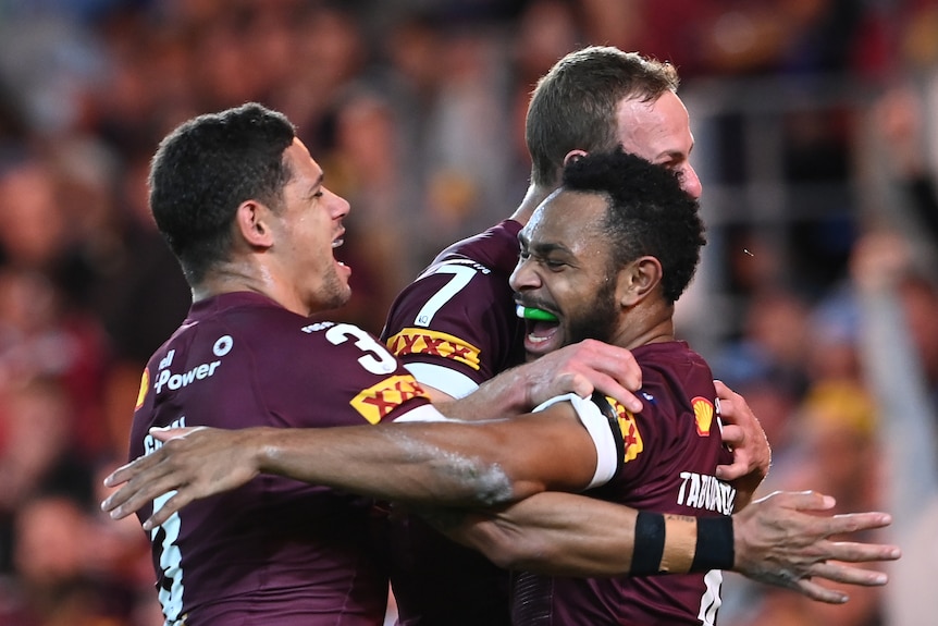 Hamiso Tabuai-Fidow, Daly Cherry-Evans and Dane Gagai hug and smile