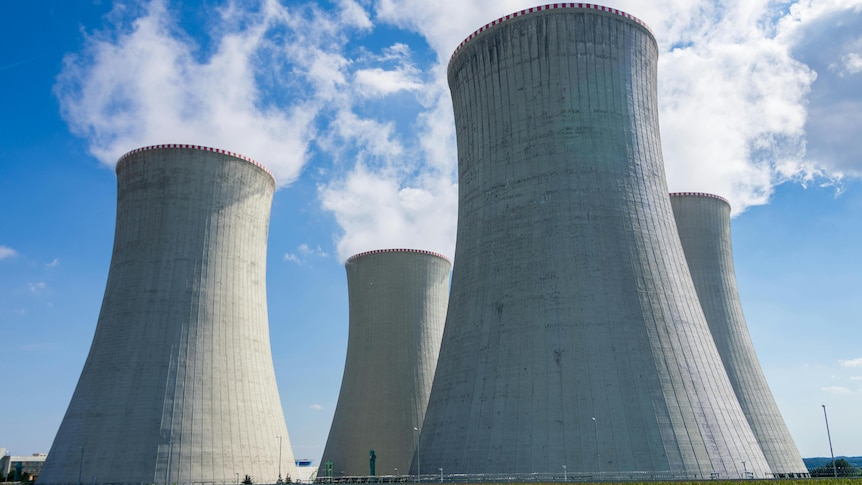 Four nuclear power station chimneys emit steam