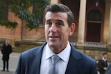 Ben Roberts-Smith wears a suit and tie as he arrives at the NSW Supreme Court.