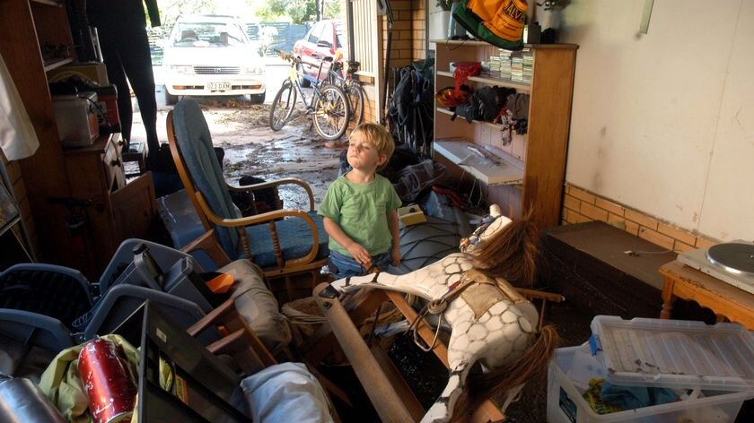 Two-year-old James surveys the flood damage at his house in The Gap.
