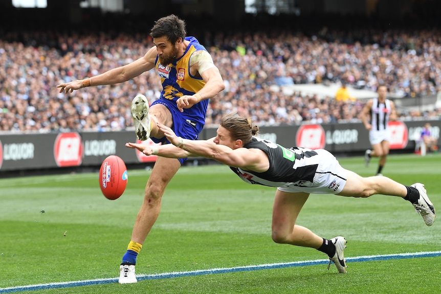 Josh Kennedy kicks as Tom Langdon dives to smother the ball