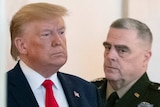 Donald Trump with Mark Milley (centre) and David Goldfein, both of whom are wearing military garb.