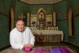 Bishop of Broome Christopher Saunders in front of pearl shell alter in the Beagle Bay church.