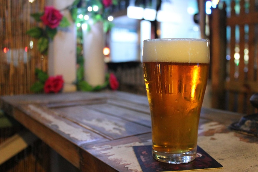 Pint of beer on a table.