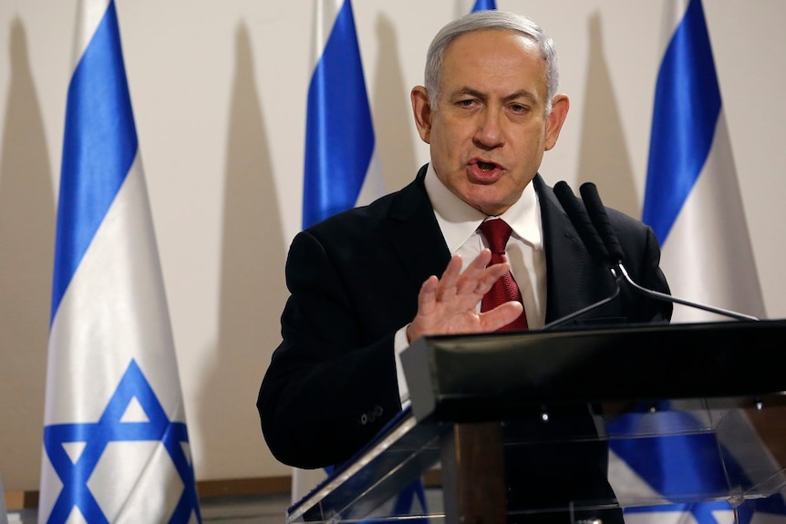 Israeli Prime Minister Benjamin Netanyahu speaking into a microphone.