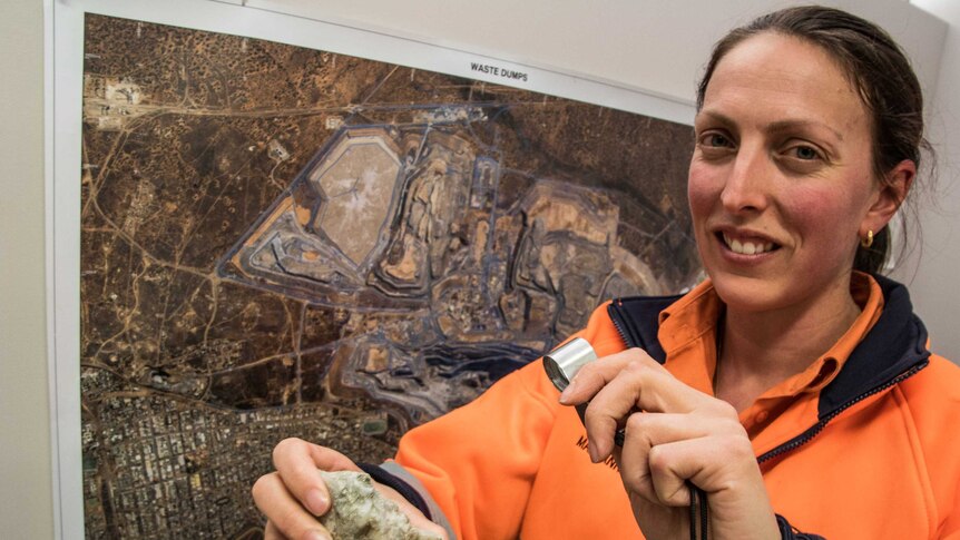 A female geologist inspecting a rock sample.