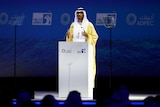 Picture of an Arab men delivering a speech at a podium 