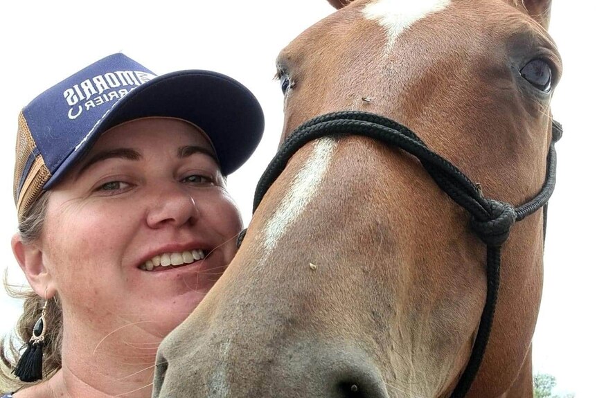 A woman and a horse take a selfie together. 