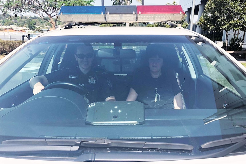 Police officer and a nurse in the front seat of a police car
