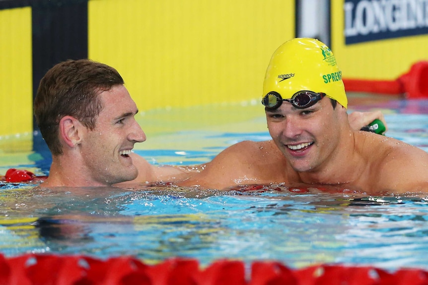 South Africa's Cameron van der Burgh (L) celebrates with Australia's Christian Sprenger (R) after the men's 50m breaststroke final