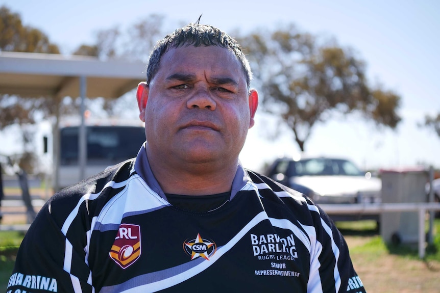 A portrait shot of Indigenous man Owen Whyman wearing a rugby league jersey in an outdoor setting.