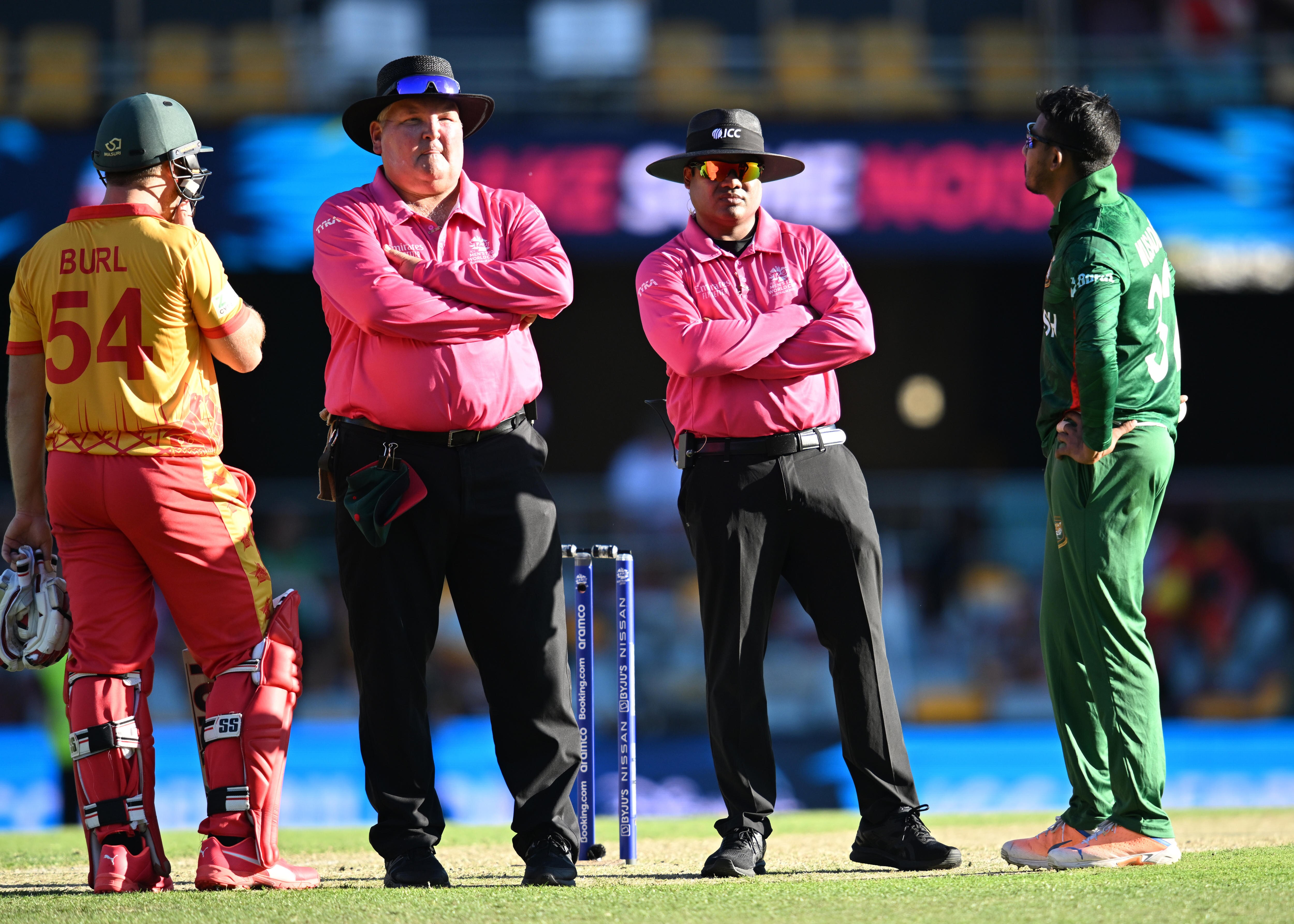 Bangladesh and Zimbabwe players speak to the umpires in the centre of the field