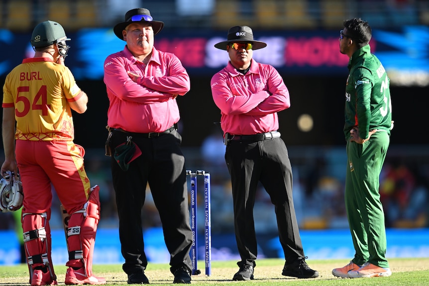 Bangladesh and Zimbabwe players speak to the umpires in the centre of the field