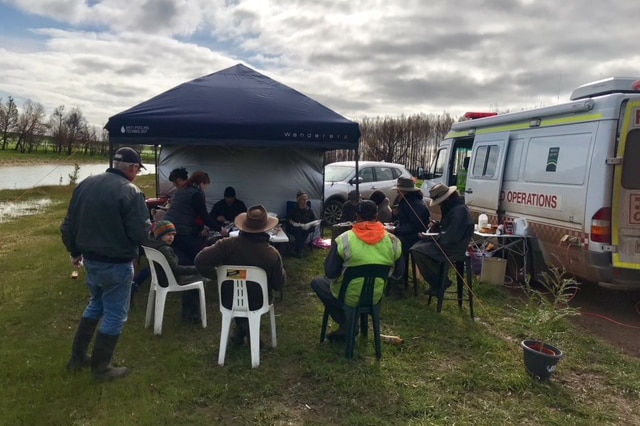 Bushfire victims from the St Patrick's Day fires gather for a sausage and a tea at a recovery van at Garvoc, in 2018