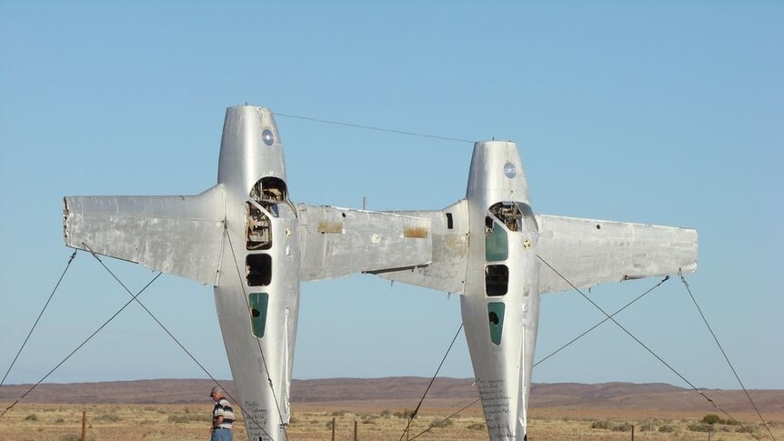 Two aeroplanes stood on their tails side-by-side in the desert