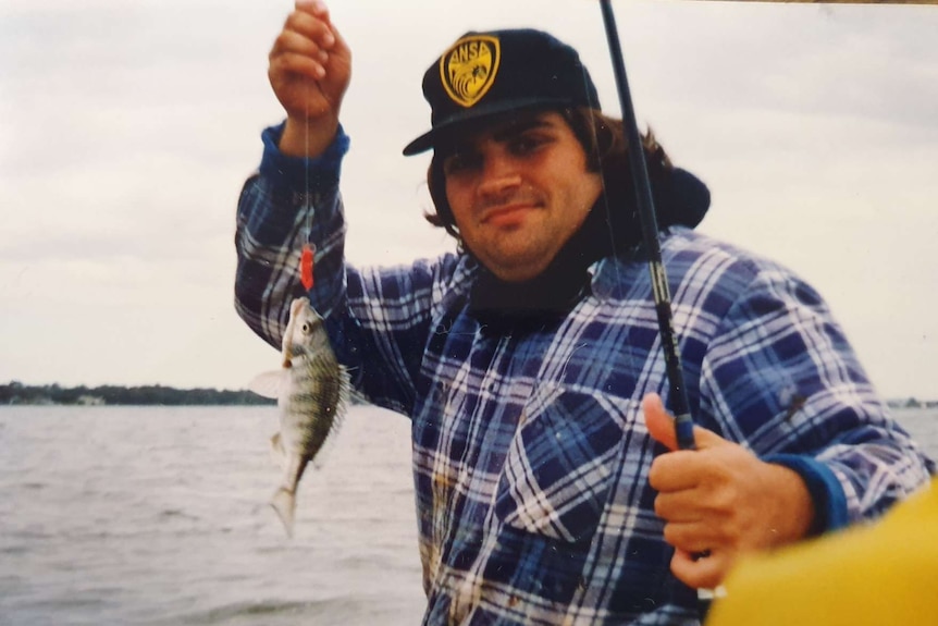 A retro shot of Stan Konstantaras shows him holding up a fish.