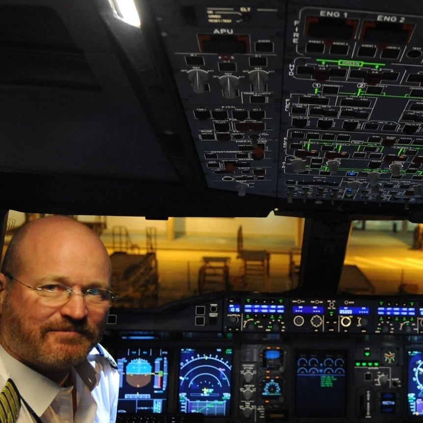 David Maddern sits in the cockpit of a plane, wearing a pilot's uniform