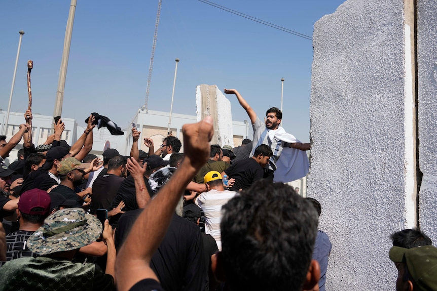 Supporters of Shiite cleric Muqtada al-Sadr try to remove concrete barriers in the Green Zone.