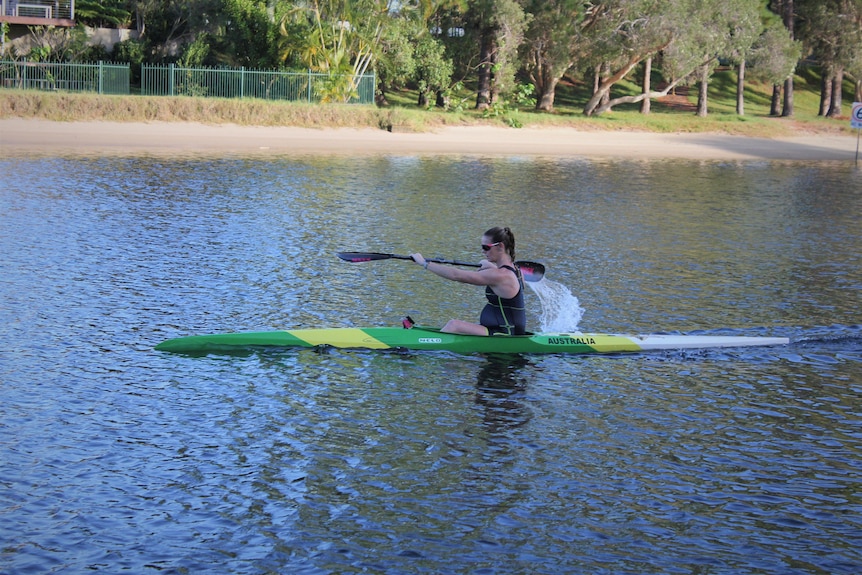 Pregnant woman paddling a kayak.
