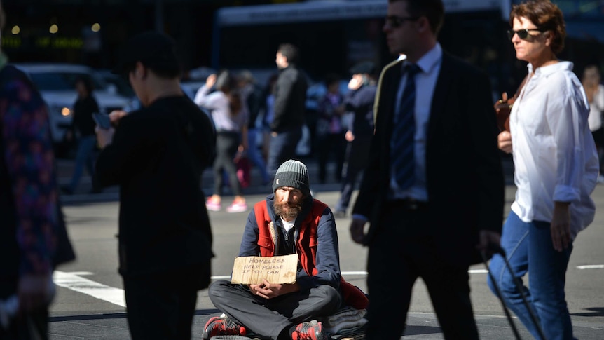 A homeless man sits on a street in Sydney as the Australian government prepares to release its budget.