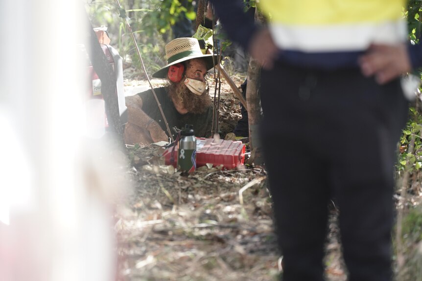 a man wearing a hat in a hole in a ground