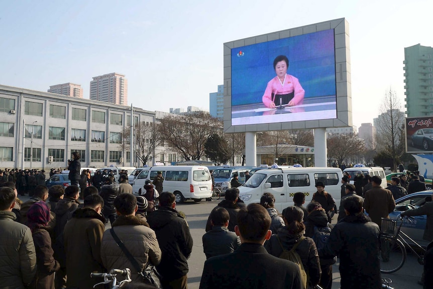 North Koreans watch a huge outdoor screen broadcasting the announcement of the hydrogen bomb test.