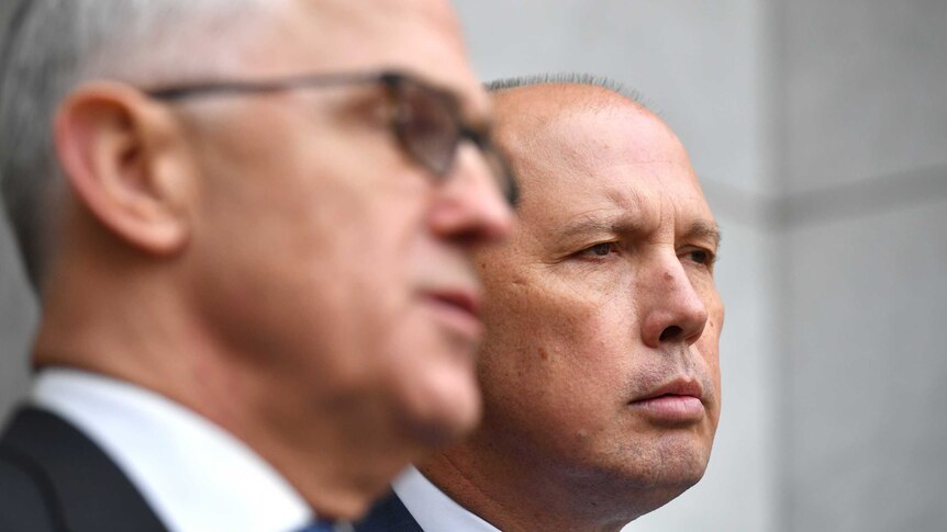 Prime Minister Malcolm Turnbull (foreground) with Peter Dutton (background) at a press conference in Canberra.
