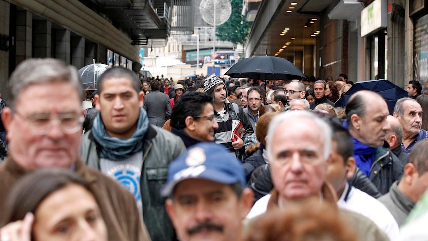 People queue to buy El Gordo Christmas lottery tickets in downtown Madrid on November 22, 2011.