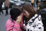 Two relatives of MH370 passengers cry.