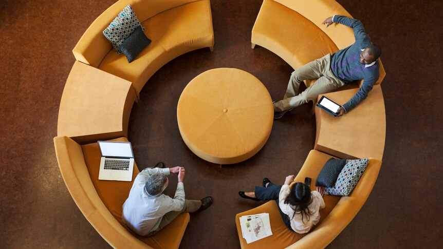 High angle view of business people talking on circular sofa