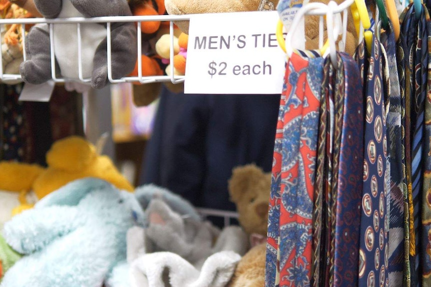 Ties are seen hanging on a rail on the right with a sign saying they are $2 each. Toys sit in racks on the left.
