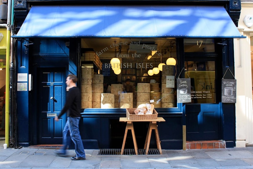 a shopfront displays stacks of cheese wheels