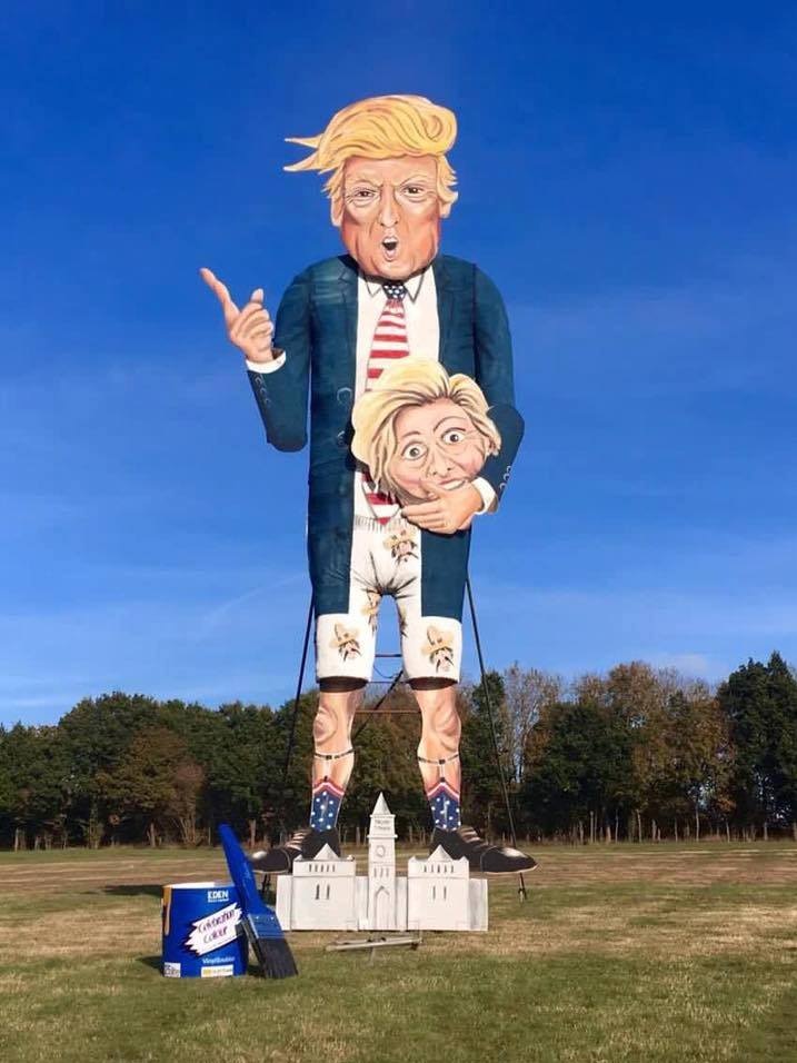 A huge effigy of Donald Trump holds Hillary Clinton's head and points a finger.
