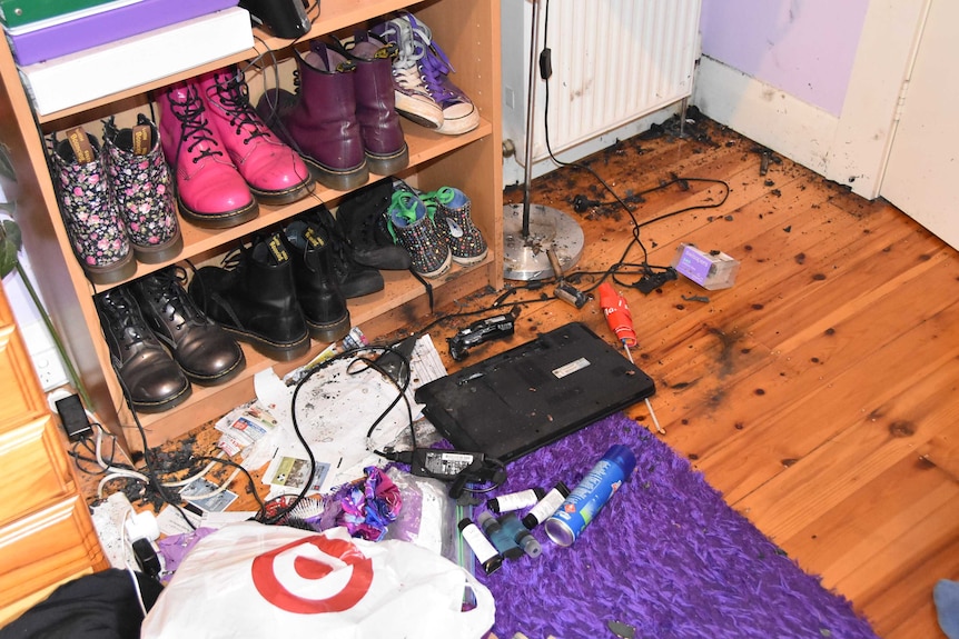 A blackened laptop and burned debris on the floor of a Melbourne woman's bedroom.