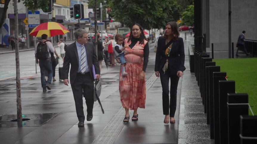 three people walking down a street in central Brisbane