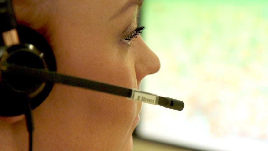 A close-up of a woman from triple zero answering phone calls.