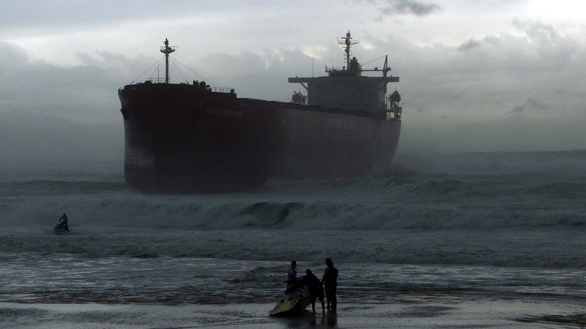 Jet ski riders on Nobbys Beach, Newcastle, are dwarfed by the MV Pasha Bulker after it ran aground there on June 8, 2007.