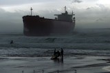 Jet ski riders on Nobbys Beach, Newcastle, are dwarfed by the MV Pasha Bulker after it ran aground there on June 8, 2007.
