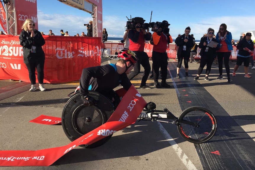 A wheelchair athlete crossing a finishing line