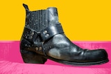 A mouldy black leather boot is seen cut out against a pink and yellow background.