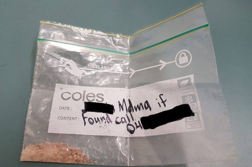 A clip seal bag with crystal powder in it labelled 'MDMA if found call