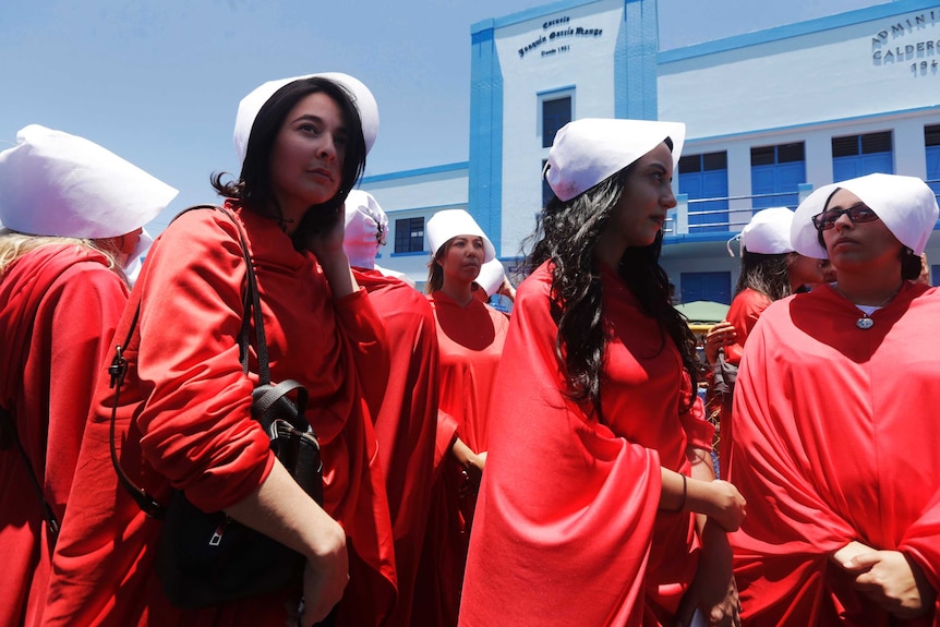 A group of women is seen dressed in a red costume from the Handmaid's Tale TV series.