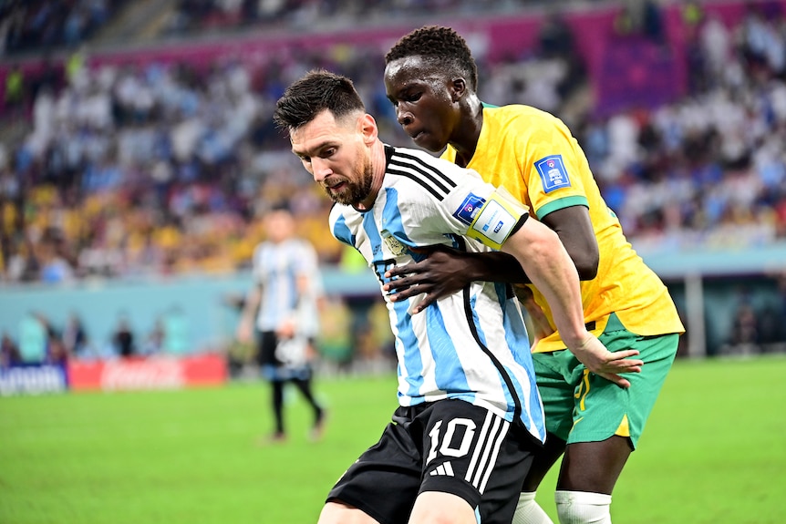 L'Argentin Lionel Messi protège le ballon du joueur de Socceroos Garang Kuol lors de la Coupe du monde au Qatar.