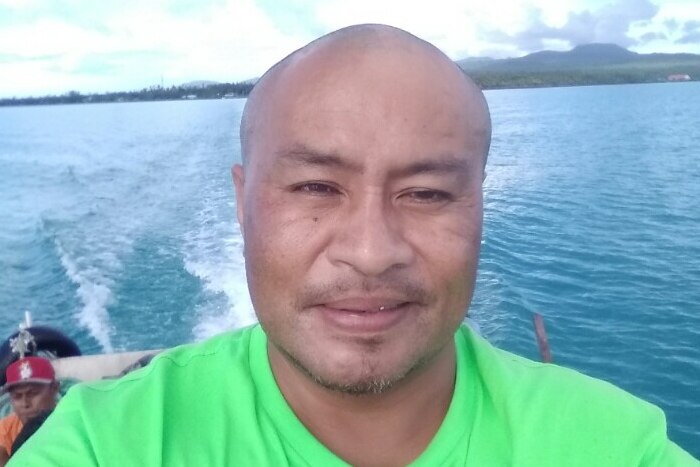 Talalelei Pauga taking a selfie on a boat, wearing a green shirt.