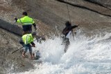 Waves wash onto fishermen on rocks at Salmon Holes in WA