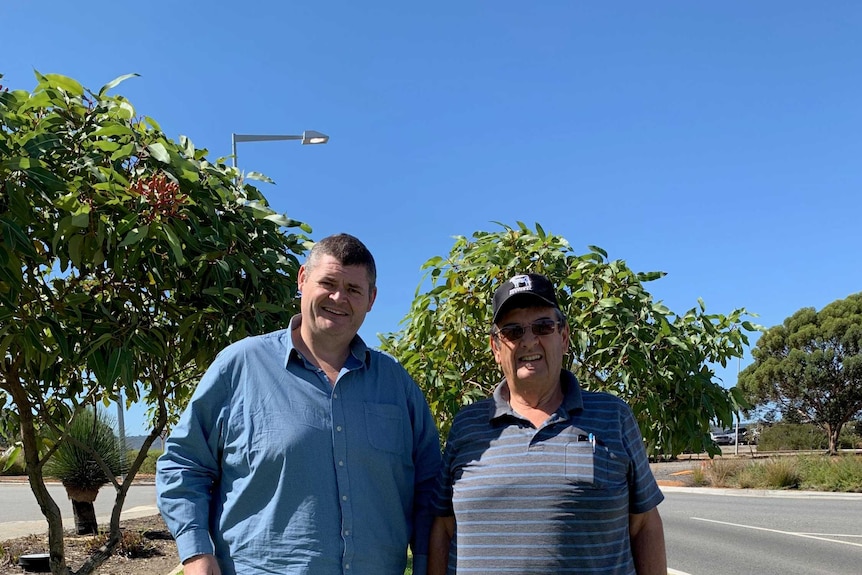 Two men stand outside