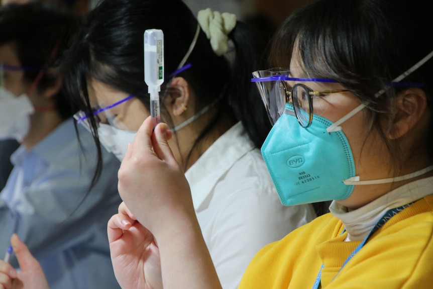 A healthcare worker prepares a vaccine at a hub in Melbourne.