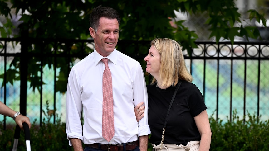 a man standing next to a woman smiling at each other